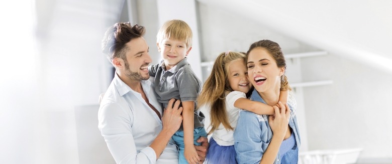 Man and woman carrying two small children