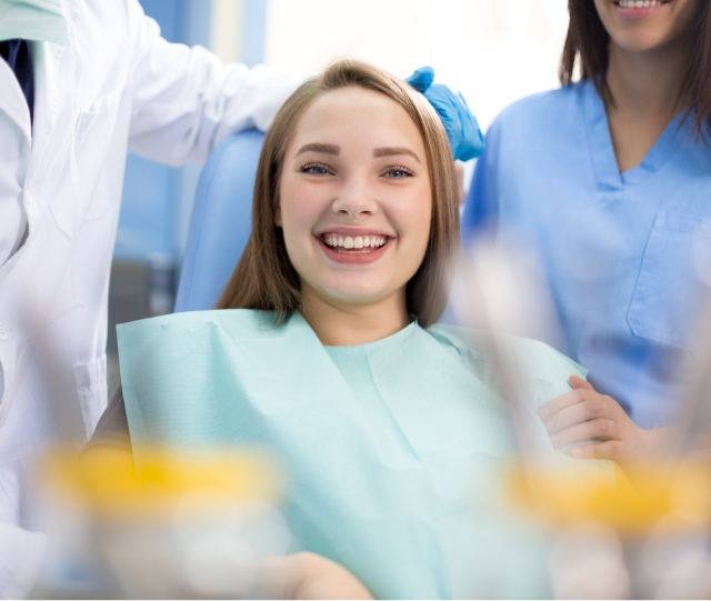 Woman sitting in dental chair and smiling