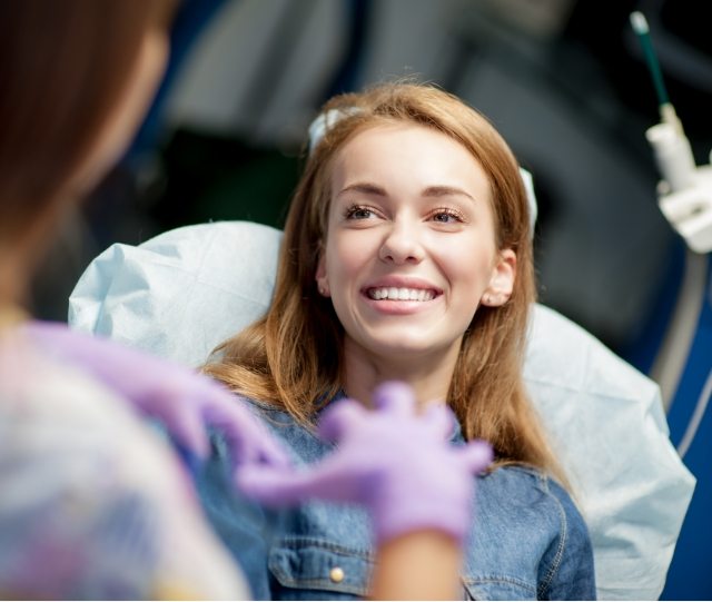 Woman smiling and looking up at dentist