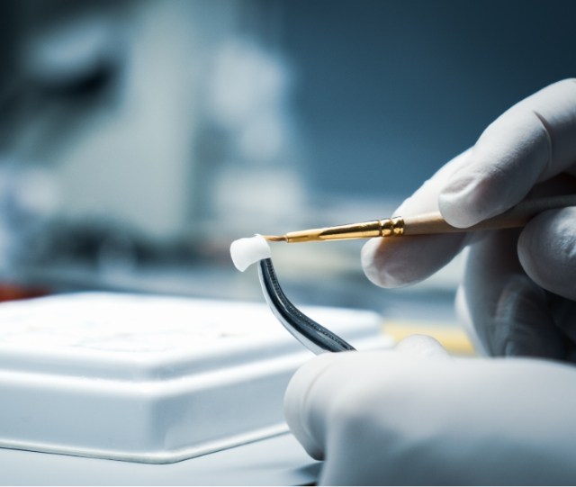 Close up of gloved hands working on dental crown