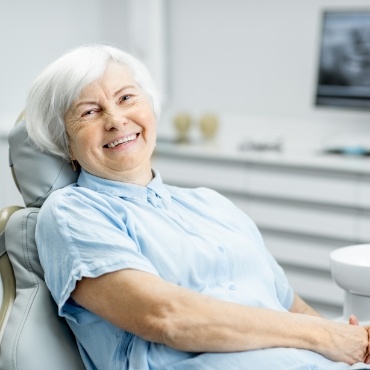 Senior woman sitting in dental chair and smiling