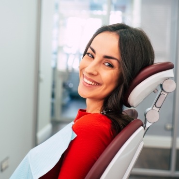 Woman in red shirt sitting in dental chair