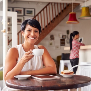 Woman sitting at table drinking coffee