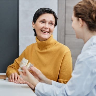 Woman in sweater talking to dentist