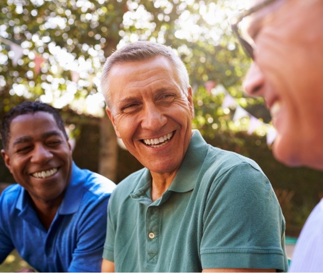 Three men sitting in a row and smiling