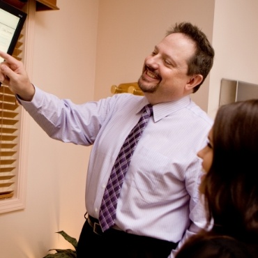 Dentist showing a patient an image on an overhead monitor