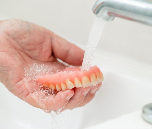 Rinsing full denture off in the sink