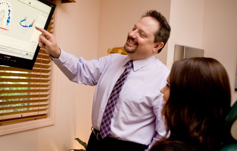 Asheville dentist Doctor John White showing patient teeth on monitor