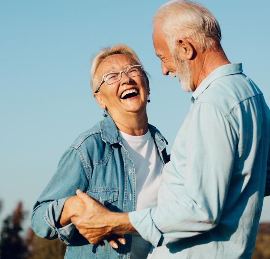 Senior man and woman standing outside and smiling