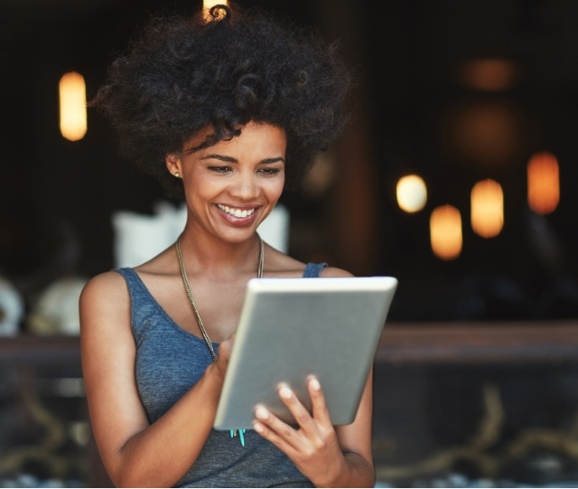 Woman looking at a tablet and smiling