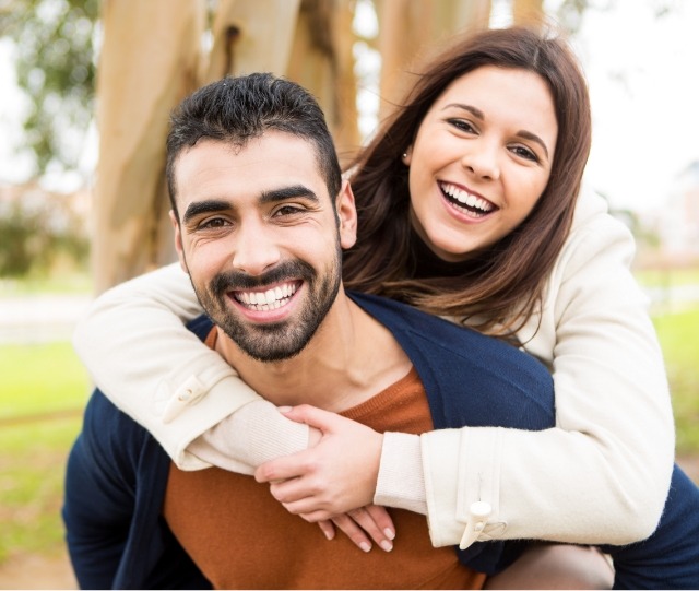 Man giving woman a piggyback ride outside